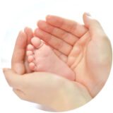 Baby feet in mother hands. Mom and her Child. Happy Family concept. Beautiful conceptual image of Maternity